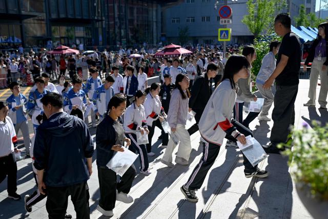 Students enter a school on the first day of China's National College Entrance Examination (NCEE) known as "gaokao", in Beijing on June 7, 2026. (Photo by WANG Zhao / AFP)