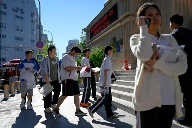 Students enter a school on the first day of China's National College Entrance Examination (NCEE) known as "gaokao", in Beijing on June 7, 2026. (Photo by WANG Zhao / AFP)