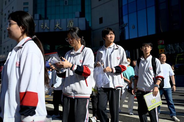 Students enter a school on the first day of China's National College Entrance Examination (NCEE) known as "gaokao", in Beijing on June 7, 2026. (Photo by WANG Zhao / AFP)