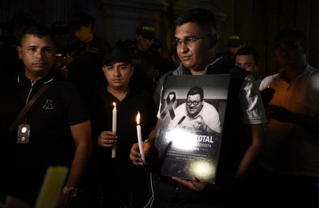 A man shows a sign in tribute to Colombian journalist Cristian Herrera during a vigil held following his murder in Cucuta, Colombia on June 6, 2026. Herrera was killed on June 6, 2026, on the Colombia-Venezuela border, following the death of another journalist attacked by guerrillas nearly a month ago according to the Ombudsman's Office. (Photo by Mauricio Saenz / AFP)