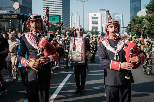Members of the Royal Jordanian Army band play the bagpipes alongside members of the marching band of the Indonesian Defence University during a street parade celebrating Jordan's Independence Day, which is celebrated annually on May 25, in Jakarta on June 7, 2026. (Photo by Yasuyoshi Chiba / AFP)