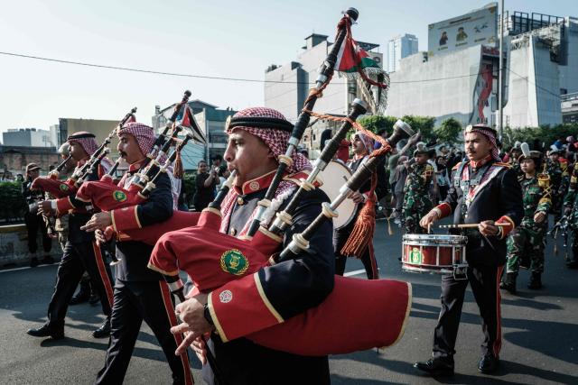 Members of the Royal Jordanian Army band play the bagpipes alongside members of the marching band of the Indonesian Defence University during a street parade celebrating Jordan's Independence Day, which is celebrated annually on May 25, in Jakarta on June 7, 2026. (Photo by Yasuyoshi Chiba / AFP)