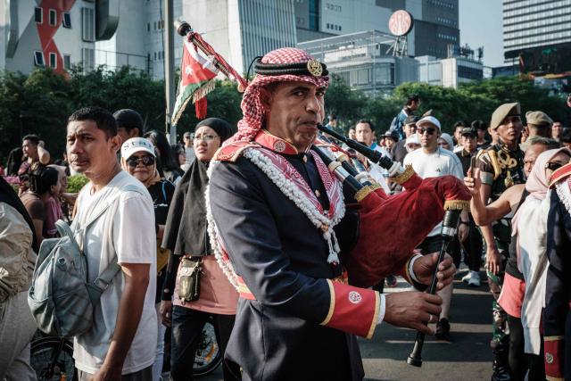 A member of the Royal Jordanian Army band warms up on the bagpipes alongside members of the marching band of the Indonesian Defence University before a street parade celebrating Jordan's Independence Day, which is celebrated annually on May 25, in Jakarta on June 7, 2026. (Photo by Yasuyoshi Chiba / AFP)