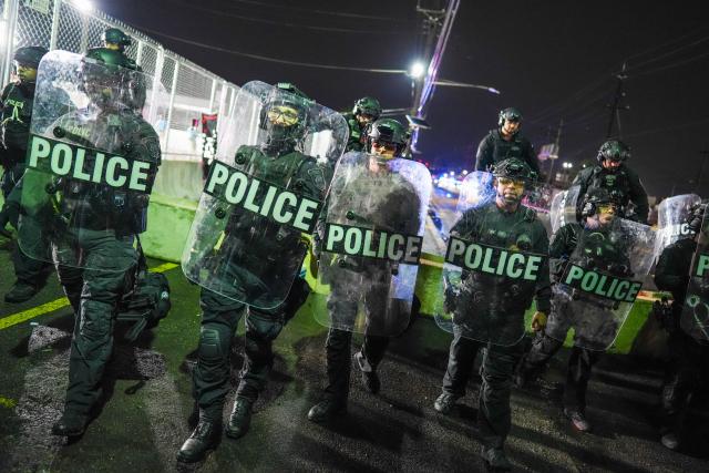 Newark police officers holding riot shields stand guard as protesters gather outside Delaney Hall, which is being used as an Immigration and Customs Enforcement (ICE) detention center, in Newark, New Jersey on June 6, 2026. The US state of New Jersey on June 2, 2026, sued the private prison company that runs the migrant detention center where protesters have rallied for several days over allegedly poor conditions at the jail. The lawsuit against GEO Group demands that local health authorities be allowed full access to Delaney Hall, one of many facilities holding people rounded up in US President Donald Trump's mass deportation sweep. (Photo by Ryan MURPHY / AFP)