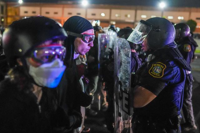 Newark police officers hold up riot shields as they push back protesters outside Delaney Hall, which is being used as an Immigration and Customs Enforcement (ICE) detention center, in Newark, New Jersey on June 6, 2026. The US state of New Jersey on June 2, 2026, sued the private prison company that runs the migrant detention center where protesters have rallied for several days over allegedly poor conditions at the jail. The lawsuit against GEO Group demands that local health authorities be allowed full access to Delaney Hall, one of many facilities holding people rounded up in US President Donald Trump's mass deportation sweep. (Photo by Ryan MURPHY / AFP)
