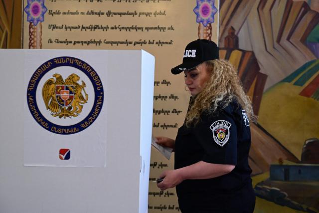 An Armenian police officer votes in the parliamentary election at a polling station in Yerevan on June 7, 2026. (Photo by Karen MINASYAN / AFP)