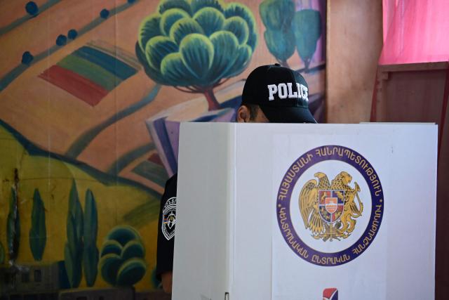 An Armenian police officer votes in the parliamentary election at a polling station in Yerevan on June 7, 2026. (Photo by Karen MINASYAN / AFP)