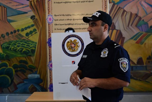 Armenian police officers vote in the parliamentary election at a polling station in Yerevan on June 7, 2026. (Photo by Karen MINASYAN / AFP)