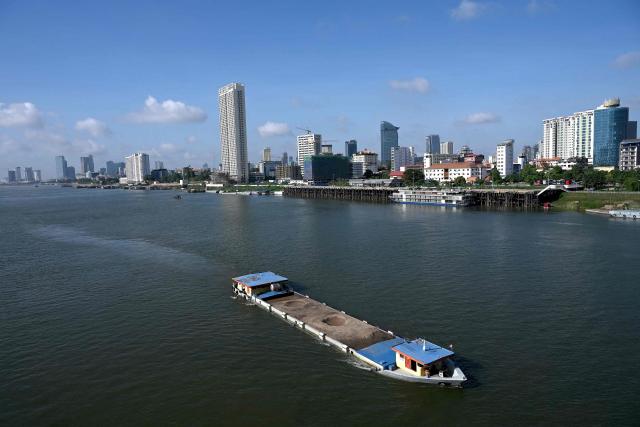 A boat loaded with soil travels along the Tonle Sap River in Phnom Penh on June 7, 2026. (Photo by TANG CHHIN Sothy / AFP)