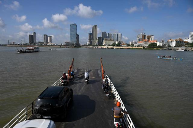 A ferry transports passengers and vehicles across the Mekong River in Phnom Penh on June 7, 2026. (Photo by TANG CHHIN Sothy / AFP)