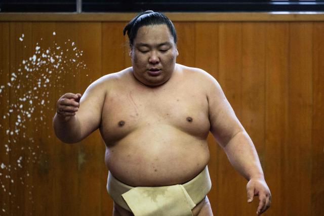 Sumo wrestler Dewanoryu throws salt to ritually cleanse the ring as he trains in the dohyo, a wrestling ring, at the Dewanoumi sumo stable in Tokyo on June 4, 2026. The stable, founded in 1862 and one of the sport's oldest, has become a major lineage in modern sumo, producing many top-division wrestlers. (Photo by Andrew CABALLERO-REYNOLDS / AFP)