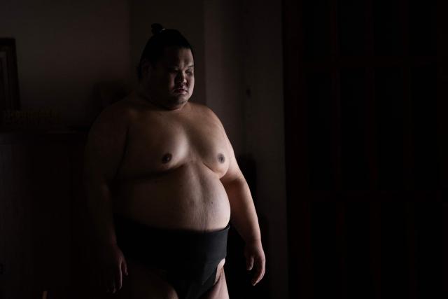 A Sumo wrestler looks on before training in the dohyo, a wrestling ring, at the Dewanoumi sumo stable in Tokyo on June 4, 2026. The stable, founded in 1862 and one of the sport's oldest, has become a major lineage in modern sumo, producing many top-division wrestlers. (Photo by Andrew CABALLERO-REYNOLDS / AFP)