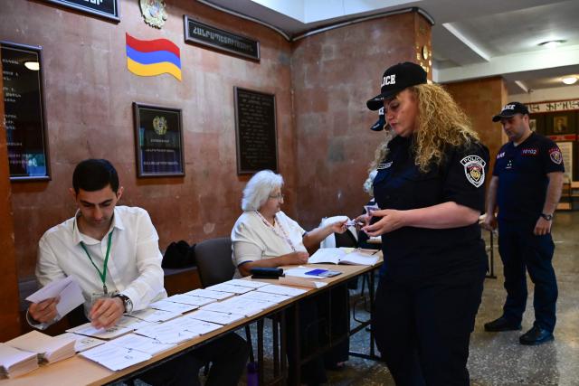 Armenian police officers vote in the parliamentary election at a polling station in Yerevan on June 7, 2026. (Photo by Karen MINASYAN / AFP)