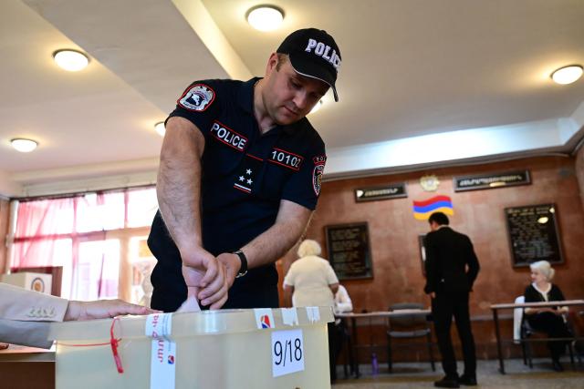 An Armenian police officer votes in the parliamentary election at a polling station in Yerevan on June 7, 2026. (Photo by Karen MINASYAN / AFP)