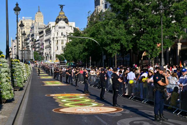 Police stand along the route of a Corpus Christi procession before a Holy Mass to be lead by Pope Leo XIV in the Plaza de Cibeles in Madrid on June 7, 2026. Pope Leo XIV is visiting Spain June 6-12 with stops in Madrid, Barcelona, and the Canary Islands, where he will meet with migrants and organisations dedicated to helping them. (Photo by Stefano RELLANDINI / AFP)