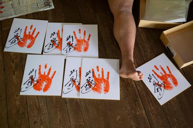 Signed sumo wrestler handprints for fans dry on the floor at the Dewanoumi sumo stable in Tokyo on June 4, 2026. The stable, founded in 1862 and one of the sport's oldest, has become a major lineage in modern sumo, producing many top-division wrestlers. (Photo by Andrew CABALLERO-REYNOLDS / AFP)