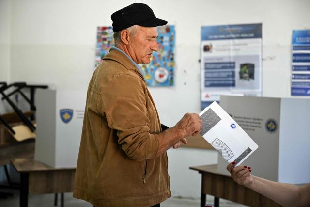 A voter is delivered his ballot at a polling station on the day of general elections in Pristina on June 7, 2026. Polls opened on June 7, 2026 for another snap election in Kosovo, its third in just over a year, as voter frustration mounts at a grinding political gridlock in Europe's youngest country, as the ballot comes after a polarised parliament failed to elect a president in April, deepening a political crisis that has gripped the country since inconclusive parliamentary elections in February 2025. (Photo by Armend NIMANI / AFP)