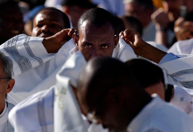 A priest puts on his religious habit before the Holy Mass to be led by Pope Leo XIV in the Plaza de Cibeles in Madrid on June 7, 2026. Pope Leo XIV is visiting Spain June 6-12 with stops in Madrid, Barcelona, and the Canary Islands, where he will meet with migrants and organisations dedicated to helping them. (Photo by Oscar DEL POZO / AFP)