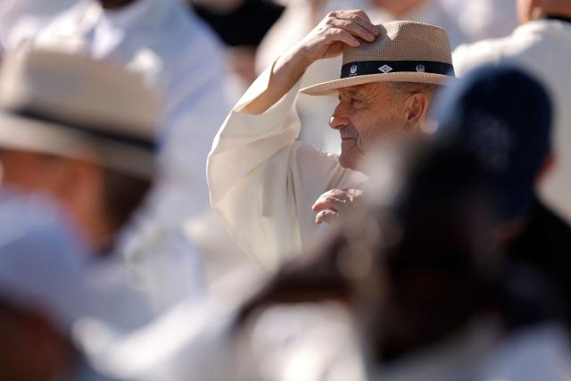A priest puts on a hat to protect himself from the sun ahead of the Holy Mass led by Pope Leo XIV in the Plaza de Cibeles in Madrid on June 7, 2026. Pope Leo XIV is visiting Spain June 6-12 with stops in Madrid, Barcelona, and the Canary Islands, where he will meet with migrants and organisations dedicated to helping them. (Photo by Oscar DEL POZO / AFP)