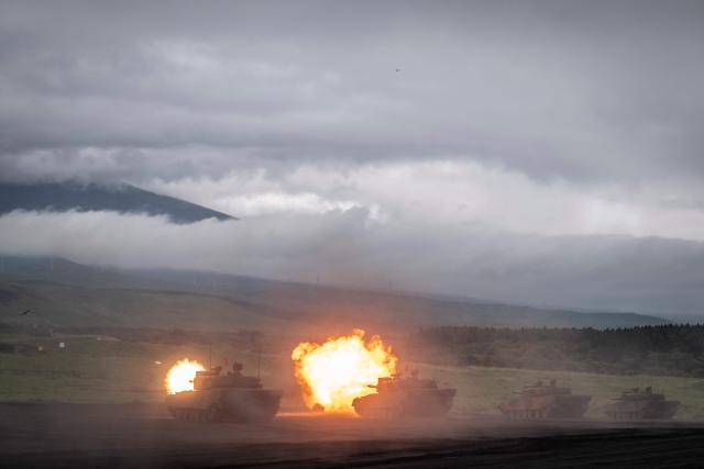 Battle tanks of the Japan Ground Self-Defense Force (JGSDF) fire their cannons during a live fire exercise at East Fuji Maneuver Area in Gotemba on June 7, 2026. (Photo by Yuichi YAMAZAKI / AFP)