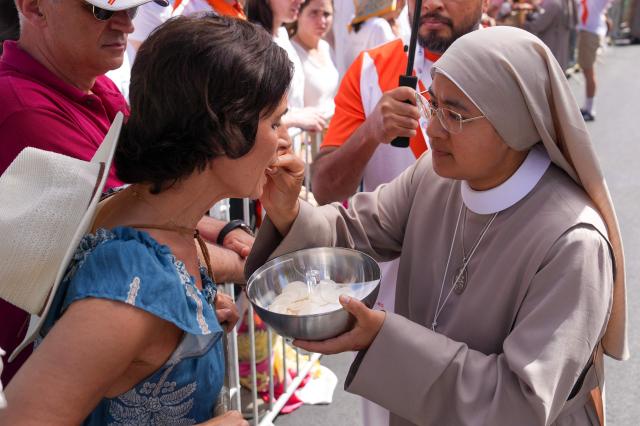A woman receives holy communion during the Holy Mass lead by Pope Leo XIV in the Plaza de Cibeles in Madrid on June 7, 2026. Pope Leo XIV is visiting Spain June 6-12 with stops in Madrid, Barcelona, and the Canary Islands, where he will meet with migrants and organisations dedicated to helping them. (Photo by Cesar MANSO / AFP)