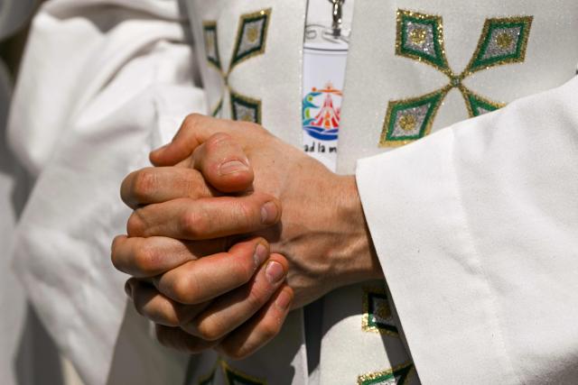 The hands of a priest are seen while attending the Holy Mass lead by Pope Leo XIV in the Plaza de Cibeles in Madrid on June 7, 2026. Pope Leo XIV is visiting Spain June 6-12 with stops in Madrid, Barcelona, and the Canary Islands, where he will meet with migrants and organisations dedicated to helping them. (Photo by Javier SORIANO / AFP)