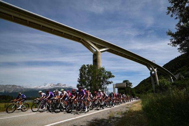 The pack of riders (peloton) cycles during the 1st stage of the Tour Auvergne-Rhone-Alpes cycling race (formerly known as the Criterium du Dauphine), 146,2km between Vizille and Saint-Ismier, in the French Alps, on June 7, 2026. (Photo by Anne-Christine POUJOULAT / AFP)