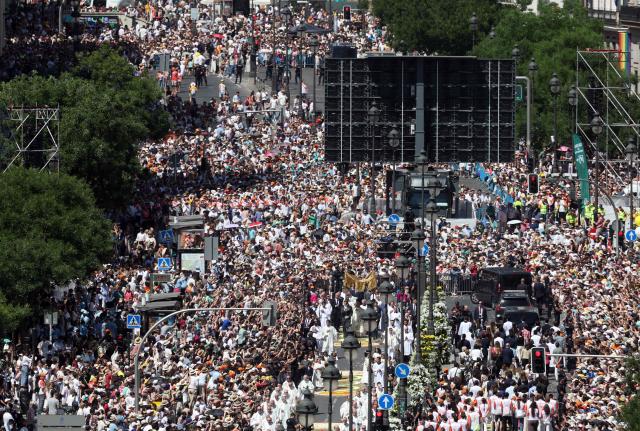The crowd packs Alcala street as Pope Leo XIV walks under a processional canopy holding the monstrance containing the sacred host during the Corpus Christi procession following the Holy Mass held in the Plaza de Cibeles in Madrid on June 7, 2026. Pope Leo XIV is visiting Spain June 6-12 with stops in Madrid, Barcelona, and the Canary Islands, where he will meet with migrants and organisations dedicated to helping them. (Photo by Pierre-Philippe MARCOU / AFP)