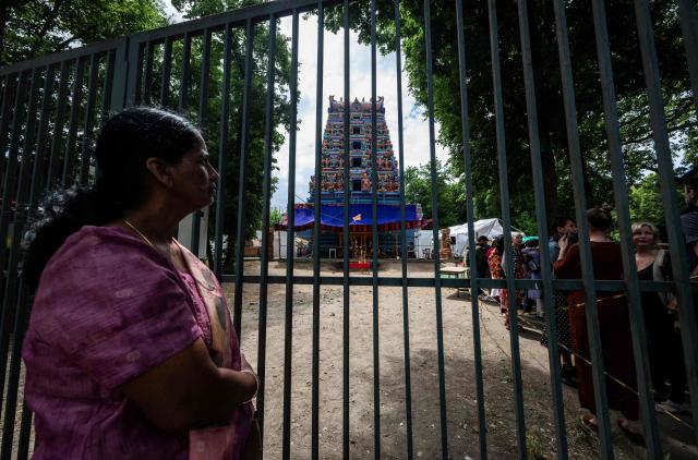 Hindu devotees and visitors queue up before entering the newly-inaugurated Sri Ganesha Temple in Berlin on June 7, 2026. The Hindu temple, dedicated to the Hindu deity Ganesha and built in South Indian Dravidian style, was consecrated on June 7 after more than two decades of planning and construction, at Hasenheide in Berlin's Neukoelln district. With its tower of over 17 metres of height, it is said to be the largest Hindu temple in Germany. The construction costs of more than one million euros were financed by donations. (Photo by John MACDOUGALL / AFP)