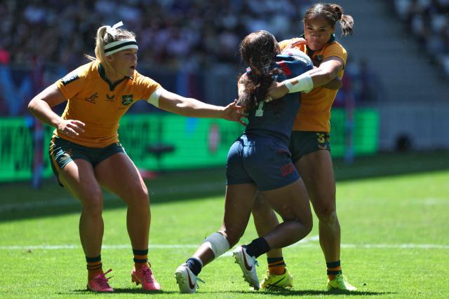 United States' Ariana Ramsey (C) is tackled by Australia's Faith Nathan (R) during the HSBC SVNS World Championship women's rugby sevens semi-final match between the United States and Australia at the Atlantique Bordeaux Metropole Stadium in Bordeaux, southwestern France, on June 7, 2026. (Photo by ROMAIN PERROCHEAU / AFP)