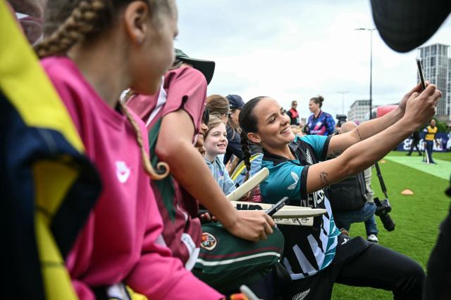 New Zealand’s Melie Kerr (R) poses for a selfie with fans during an exhibition at The Captains' Carnival, the activation event for the ICC Women's T20 cricket world cup 2026, in central London on June 7, 2026. (Photo by JUSTIN TALLIS / AFP)
