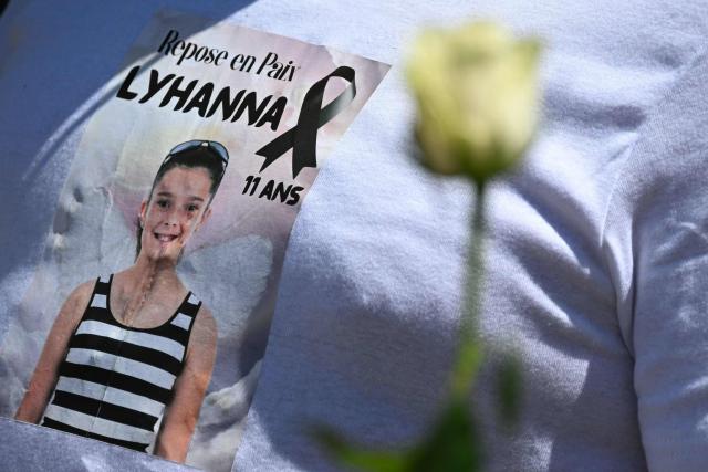 Relatives and people walk as they take part in a silent march in tribute to Lyhanna, an 11-year-old girl found dead on June 4 after having been reported missing since May 29, 2026, in Fleurance, southwestern France, on June 7, 2026. Outrage has erupted in France after it emerged the main suspect Jerome.B, a 41-year-old father of two, had been repeatedly accused of sexually abusing children but no action was taken to protect others. The sticker with a photo of Lyhanna reads "Rest in peace". (Photo by Lionel BONAVENTURE / AFP)