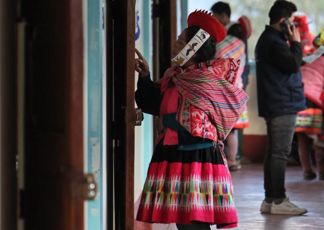 A local resident checks a list before voting during the presidential election runoff at a polling station in Ollantaytambo, department of Cusco, Peru, on June 7, 2026. Peruvians will choose their ninth president in 10 years in a tight runoff election between conservative Keiko Fujimori and leftist Roberto Sanchez, who are trying to woo voters fed up with political chaos and rising crime. (Photo by Jose Angulo / AFP)