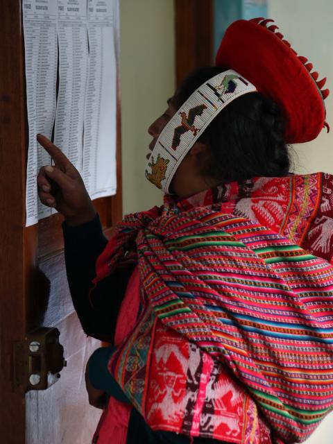 A local resident checks a list before voting during the presidential election runoff at a polling station in Ollantaytambo, department of Cusco, Peru, on June 7, 2026. Peruvians will choose their ninth president in 10 years in a tight runoff election between conservative Keiko Fujimori and leftist Roberto Sanchez, who are trying to woo voters fed up with political chaos and rising crime. (Photo by Jose Angulo / AFP)