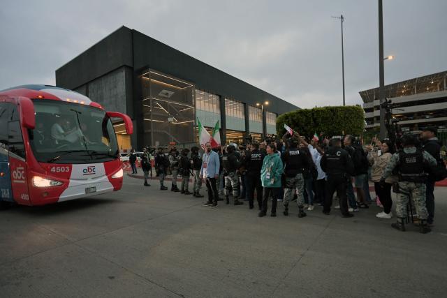 Football fans cheer as Iran's players leave the Tijuana International Airport on a bus in Tijuana, Mexico on June 7, 2026, ahead of the FIFA 2026 World Cup football tournament. (Photo by Guillermo Arias / AFP)