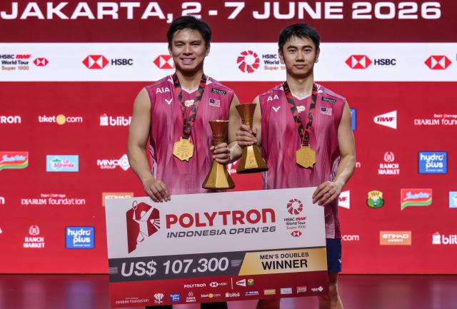 Malaysia's Goh Sze Fei and Nur Izzuddin pose during the medal ceremony after winning their men's doubles final match against Indonesia's Raymond Indra and Nikolaus Joaquin at the Indonesia Open badminton tournament in Jakarta on June 7, 2026. (Photo by BAY ISMOYO / AFP)