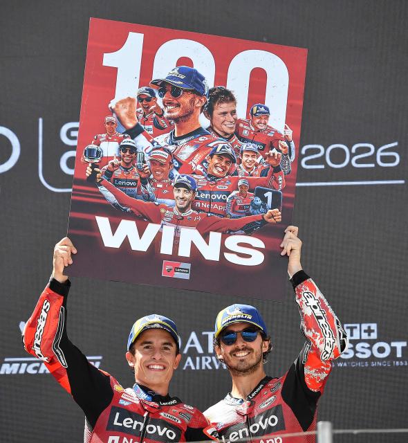Winner Team Ducati Lenovo Team's Marc Marquez (L) and third placed Team Ducati Lenovo Team's Francesco Bagnaia celebrate with a sign to mark Marquez' 100-win mark on the podium of the Hungarian Motorcycle MotoGP Grand Prix at the Balaton Park circuit in Balatonfokajar, Hungary, on June 7, 2026. (Photo by Ferenc ISZA / AFP)