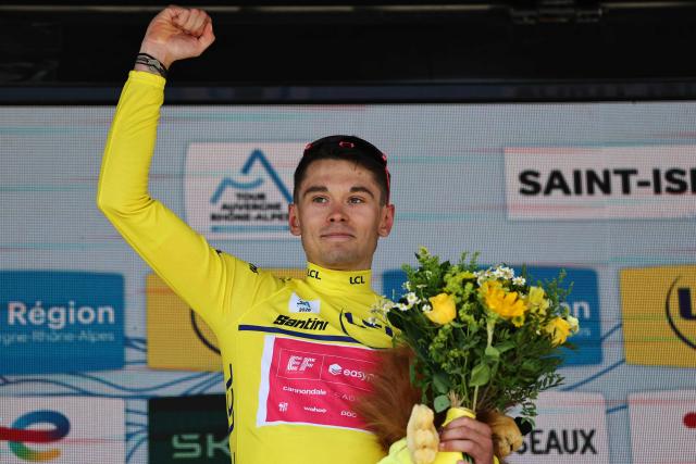 EF Education - EasyPost's French rider Alex Baudin celebrates with the overall leader's yellow jersey on the podium after the 1st stage of the Tour Auvergne-Rhone-Alpes cycling race (formerly known as the Criterium du Dauphine), 146,2km between Vizille and Saint-Ismier, in the French Alps, on June 7, 2026. (Photo by Anne-Christine POUJOULAT / AFP)