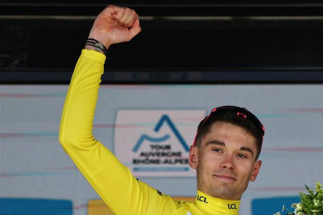 EF Education - EasyPost's French rider Alex Baudin celebrates with the overall leader's yellow jersey on the podium after the 1st stage of the Tour Auvergne-Rhone-Alpes cycling race (formerly known as the Criterium du Dauphine), 146,2km between Vizille and Saint-Ismier, in the French Alps, on June 7, 2026. (Photo by Anne-Christine POUJOULAT / AFP)