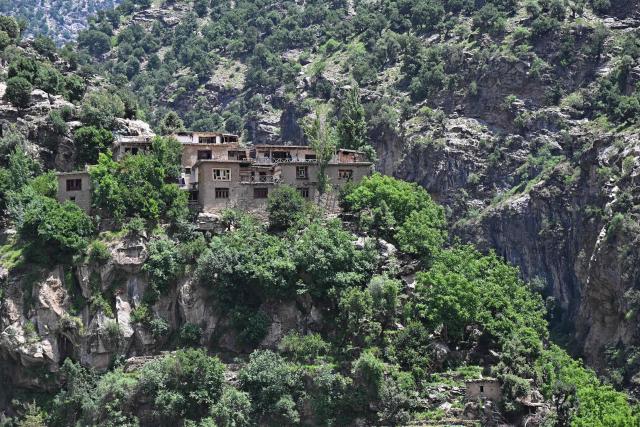 Residential buildings overlook a hilltop at the Archa Naw area in Wama district, Nuristan province on June 7, 2026. (Photo by Wakil KOHSAR / AFP)