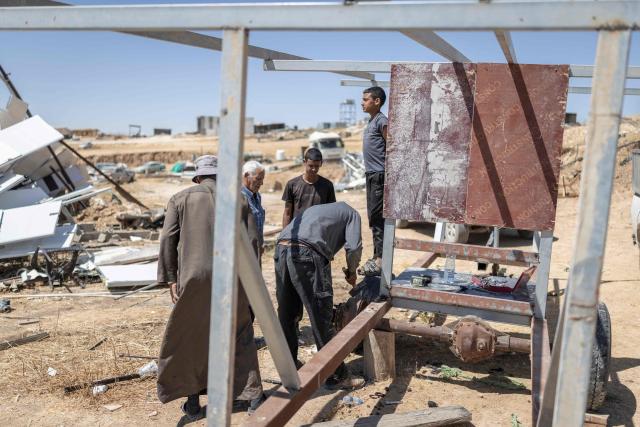 Men dismantle a structure of a caravan at the Bedouin community of Tel Arad, that is being self demolished ahead of a date that was given to the residents by Israeli authorities in Negev desert, in southern Israel on June 7, 2026. (Photo by Ilia YEFIMOVICH / AFP)