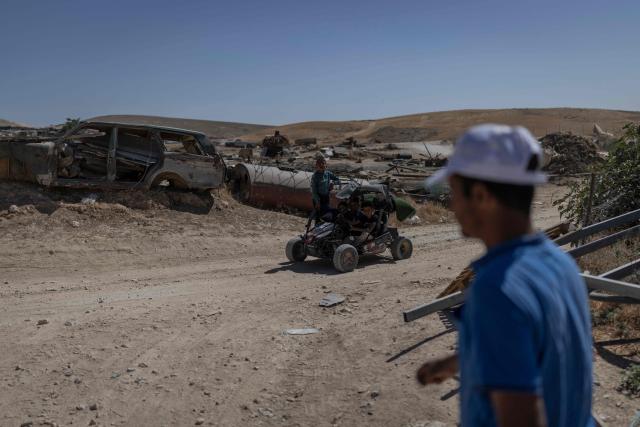 Children ride an off-road buggy at the Bedouin community in Tel Arad, that is being self demolished ahead of a date that was given to the residents by Israeli authorities in Negev desert, in southern Israel on June 7, 2026. (Photo by Ilia YEFIMOVICH / AFP)