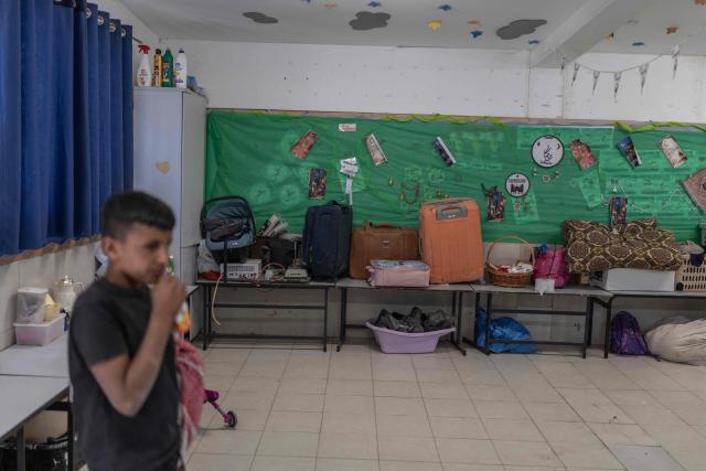 A boy stands inside the classroom of a school housing the belongings of the residents of the Bedouin community of Tel Arad, that is being self demolished ahead of a date that was given to the residents by Israeli authorities in Negev desert, in southern Israel on June 7, 2026. (Photo by Ilia YEFIMOVICH / AFP)