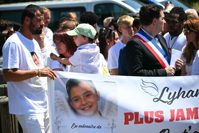 (LtoR) Lyhanna's father and mother Martial Bernard and Charly Rameau and Fleurance mayor Gregory Bobbato take part in a silent march in tribute to Lyhanna, an 11-year-old girl found dead on June 4 after having been reported missing since May 29, in Fleurance, southwestern France, on June 7, 2026. Outrage has erupted in France after it emerged the main suspect Jerome.B, a 41-year-old father of two, had been repeatedly accused of sexually abusing children but no action was taken to protect others. The inscription on the jerseys reads : "Never again !". (Photo by Lionel BONAVENTURE / AFP)