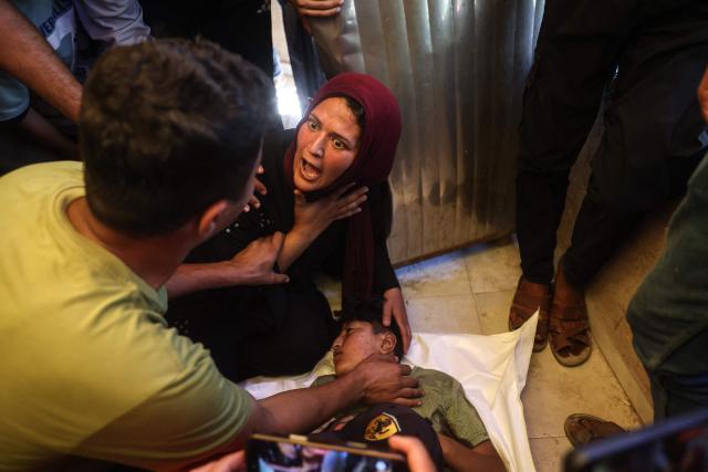EDITORS NOTE: Graphic content / A woman reacts as she mourns over the body of a victim killed in a reported Israeli airstrike on a police station in the Al-Mawasi district, during a funeral at Nasser Hospital in Khan Yunis, southern Gaza Strip, on June 7, 2026. Gaza's civil defence service said an Israeli airstrike on a police station killed at least five people on June 7, and wounded several, as violence raged unabated across the Palestinian territory. Israel and Hamas continue to trade accusations of near-daily ceasefire violations, keeping the Gaza Strip locked in bloodshed months after a truce took effect in October. (Photo by Bashar Taleb / AFP)