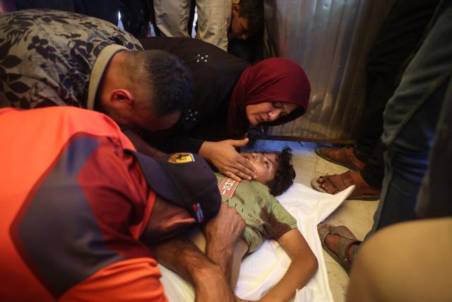 EDITORS NOTE: Graphic content / A woman mourns over the body of a victim killed in a reported Israeli airstrike on a police station in the Al-Mawasi district, during a funeral at Nasser Hospital in Khan Yunis, southern Gaza Strip, on June 7, 2026. Gaza's civil defence service said an Israeli airstrike on a police station killed at least five people on June 7, and wounded several, as violence raged unabated across the Palestinian territory. Israel and Hamas continue to trade accusations of near-daily ceasefire violations, keeping the Gaza Strip locked in bloodshed months after a truce took effect in October. (Photo by Bashar Taleb / AFP)