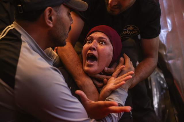 TOPSHOT - A woman reacts as she mourns over the body of a victim killed in a reported Israeli airstrike on a police station in the Al-Mawasi district, during a funeral at Nasser Hospital in Khan Yunis, southern Gaza Strip, on June 7, 2026. Gaza's civil defence service said an Israeli airstrike on a police station killed at least five people on June 7, and wounded several, as violence raged unabated across the Palestinian territory. Israel and Hamas continue to trade accusations of near-daily ceasefire violations, keeping the Gaza Strip locked in bloodshed months after a truce took effect in October. (Photo by Bashar Taleb / AFP)