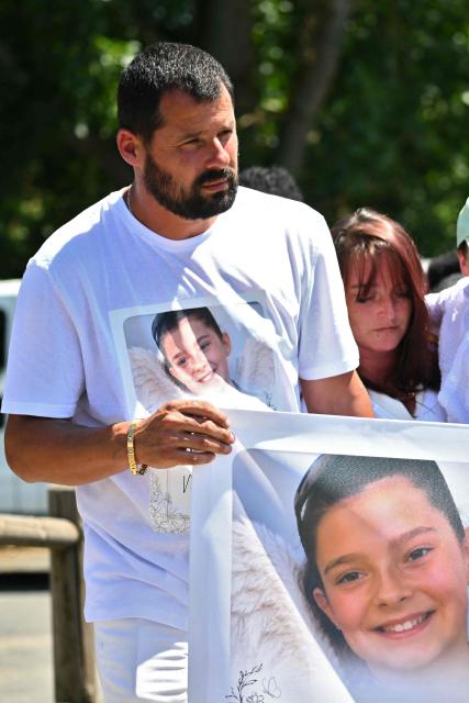 Lyhanna's father Martial Bernard takes part in a silent march in tribute to Lyhanna, an 11-year-old girl found dead on June 4 after having been reported missing since May 29, in Fleurance, southwestern France, on June 7, 2026. Outrage has erupted in France after it emerged the main suspect Jerome.B, a 41-year-old father of two, had been repeatedly accused of sexually abusing children but no action was taken to protect others. The inscription on the jerseys reads : "Never again !". (Photo by Lionel BONAVENTURE / AFP)