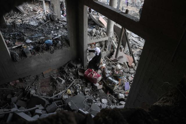A Palestinian woman stands amid debris at the site of an Israeli airstrike in Khan Yunis, southern Gaza Strip, on June 7, 2026. Israel and Hamas accuse each other of near-daily violations of the truce meant to halt the war in Gaza, which was triggered by Hamas's October 7, 2023 attack on Israel. At least 961 Palestinians have been killed since the ceasefire took effect on October 10 last year, according to Gaza's health ministry, which operates under Hamas authority and whose figures are considered reliable by the United Nations. The Israeli army has reported five deaths in its ranks during the same period. (Photo by Bashar Taleb / AFP)