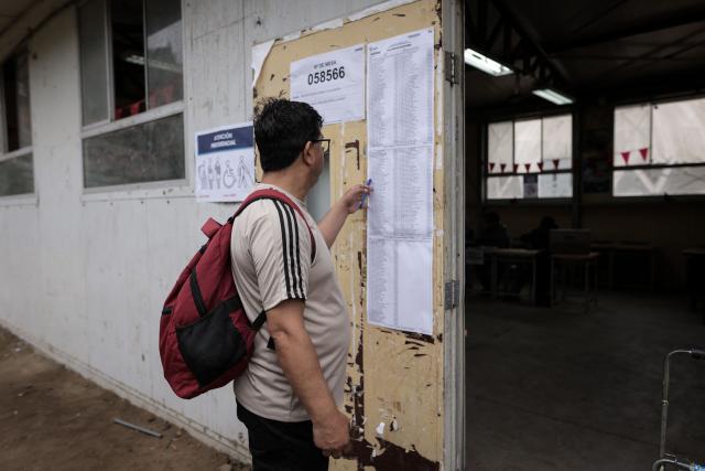 A man looks at an information placard at a polling station during the presidential election runoff in San Juan de Lurigancho district, province of Lima, Peru, on June 7, 2026. Peruvians will choose their ninth president in 10 years in a tight runoff election between conservative Keiko Fujimori and leftist Roberto Sanchez, who are trying to woo voters fed up with political chaos and rising crime. (Photo by Anthony Nino de Guzman / AFP)